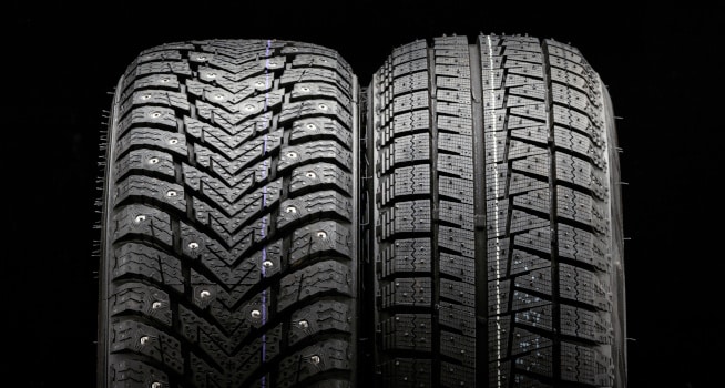 close up of 2 tyres side by side against a black background